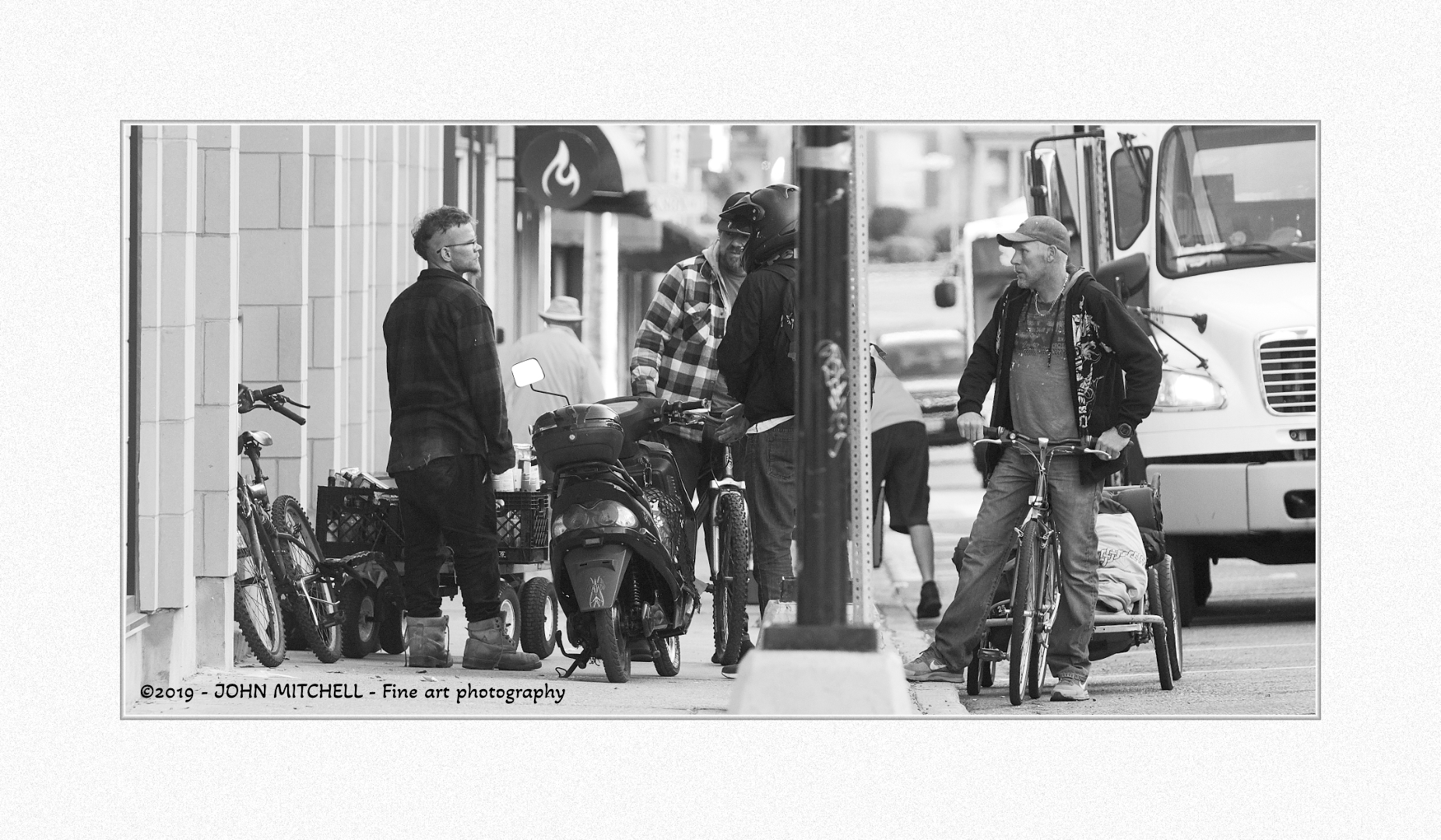 Black and dwhite photo of youth blockng the sidewalk.